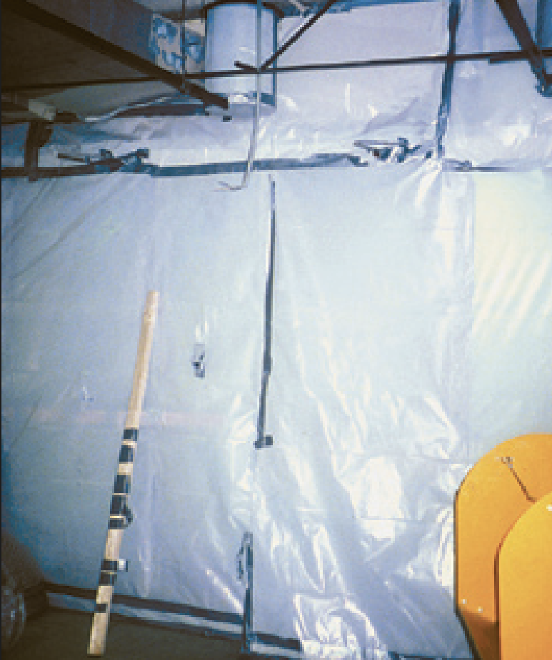 A contained remediation work area behind protective sheeting